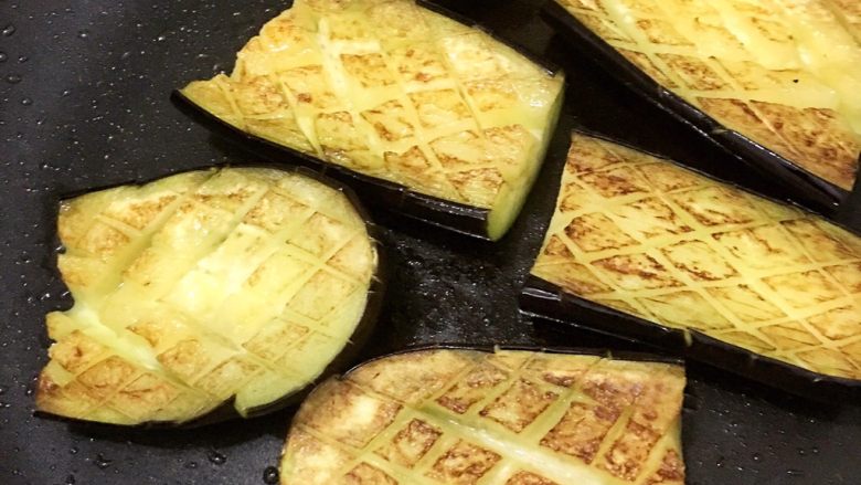 筷头停不下来的肉沫蒸茄子,锅里油烧至三四成热,放入茄子,小火煎至茄子刀痕膨胀,茄子两面色焦黄后,控油捞出