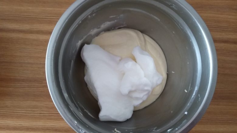 乳酪蛋糕,取三分之一蛋白和蛋黄糊混合,用硅胶刀画J字,搅拌均匀
