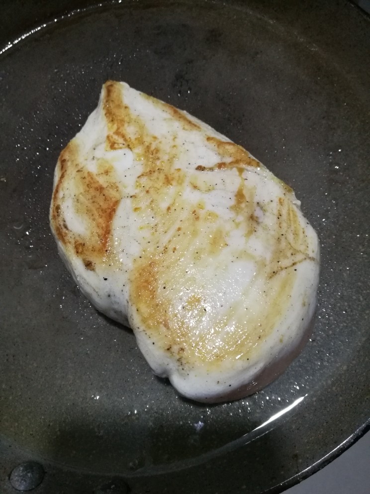 快手日式照烧鸡排饭,煎锅刷层薄油,热锅后加入腌制好的鸡胸肉。中火慢煎,煎到一面金黄色,翻面继续煎。