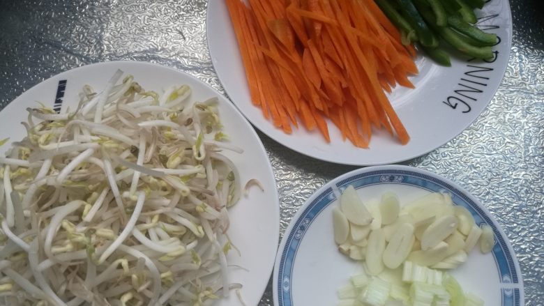 素味炒饼,
2、豆芽菜清洗干净,<a style='color:red;display:inline-block;' href='/shicai/ 61'>青椒</a>切成丝,红萝卜切丝,葱切碎,蒜切片。