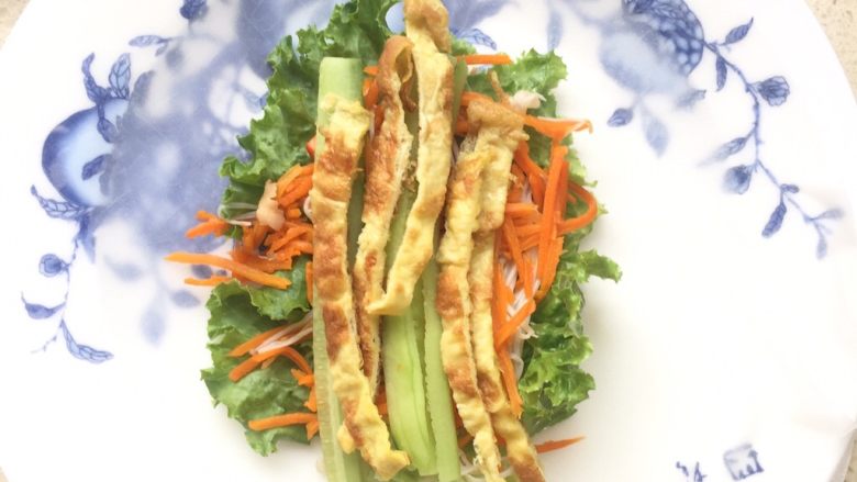 越南春卷,将泡好后的米皮平铺于盘子中 最下层放<a style='color:red;display:inline-block;' href='/shicai/ 287'>虾仁</a> 然后依次放上生菜 金针菇 黄瓜丝 豆芽 彩椒丝 鸡蛋丝等