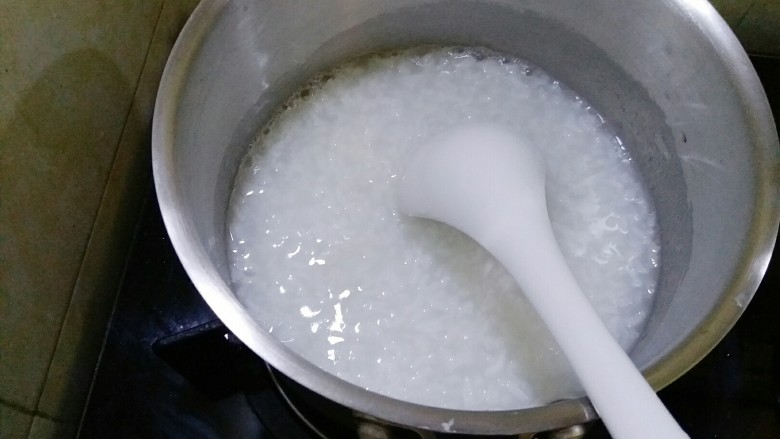 宝宝辅食 快手版菠菜牛肉粥,把煮好的白粥转移到小奶锅里。锅刚买的,那个即将退休。