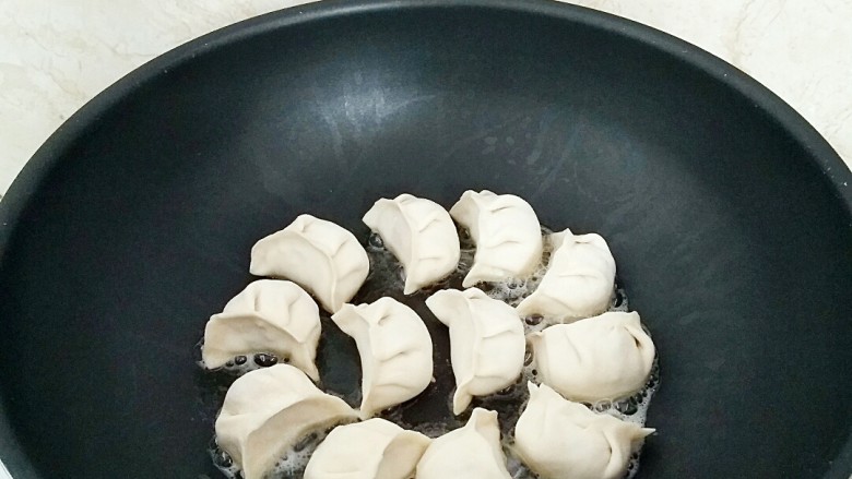 鲜肉灌汤煎饺,煎锅刷2汤匙油烧热,摆放煎饺。
