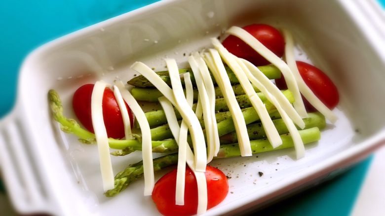素食早餐,<a style='color:red;display:inline-block;' href='/shicai/ 122'>芦笋</a>、小番茄放入烤盘,撒黑胡椒和少许海盐,上面盖上马苏里拉奶酪丝,放入烤箱150度约10分钟,奶酪烤化即可。