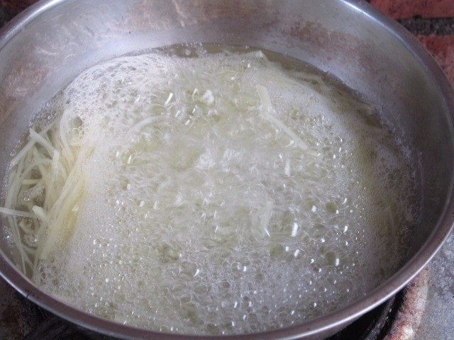 土豆丝卷饼,煮锅沸水,下入土豆丝焯2分钟。