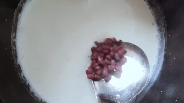红豆椰奶西米露,然后放入待用的红小豆,汤勺搅拌关火
