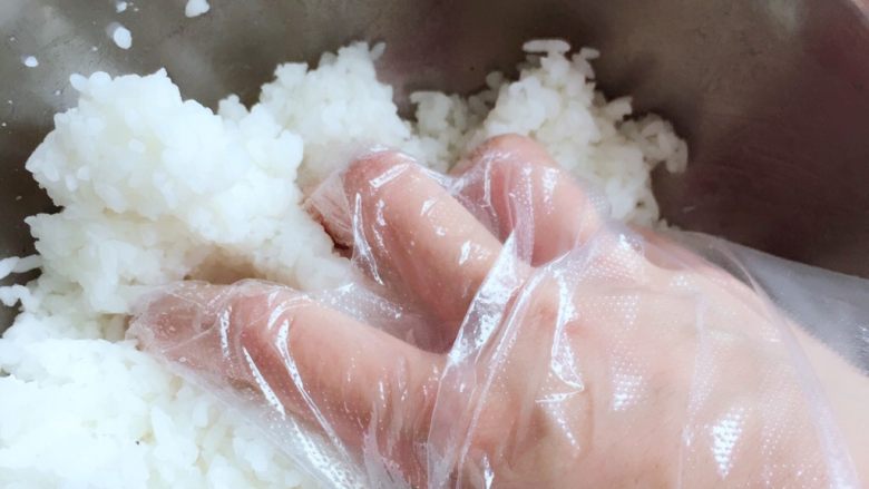 紫菜包饭,将寿司醋适量加入米饭中,戴上一次性手套抓饭