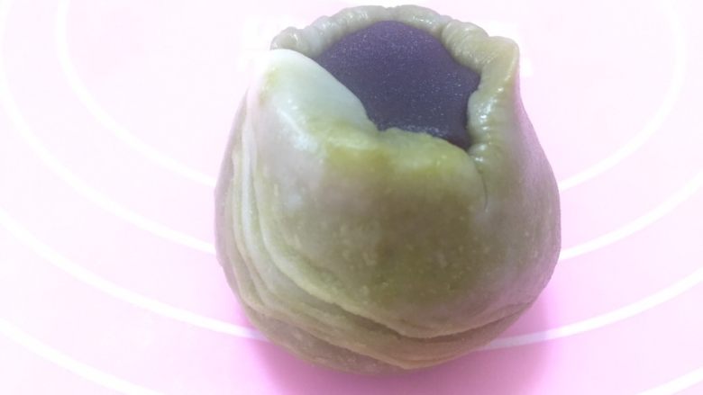 花样蛋黄酥,在没有纹路一面加入豆沙蛋黄馅,放入虎口收口。具体操作可参考三色蛋黄酥视频课程。