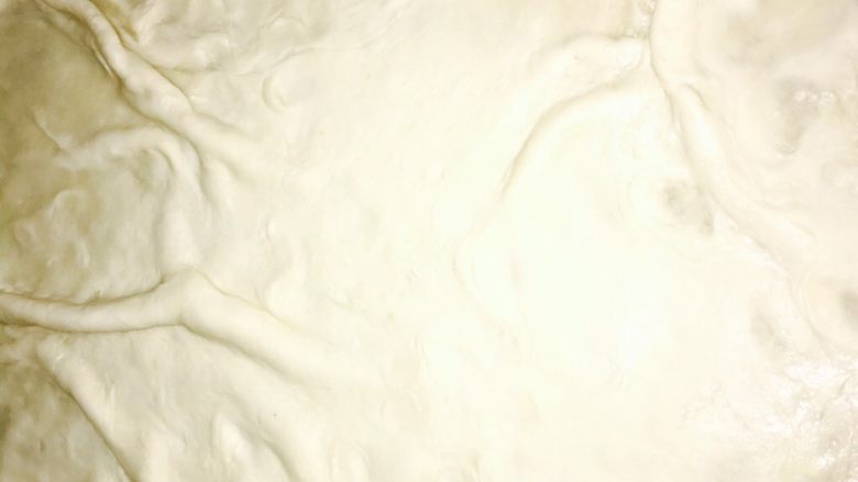 美味酱香饼,饼铛放油烧热放入擀好的薄饼片,如图:放出一些褶皱小火慢烙