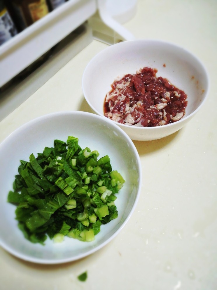 电饭煲之青菜瘦肉粥,瘦肉切片或丝，尽量切薄一点。加入<a style='color:red;display:inline-block;' href='/shicai/ 788'>生抽</a>，<a style='color:red;display:inline-block;' href='/shicai/ 718'>料酒</a>，<a style='color:red;display:inline-block;' href='/shicai/ 720'>胡椒粉</a>，姜片腌制待用。喜欢滑嫩口感的，可以在瘦肉入电饭煲前加少许生粉。
<a style='color:red;display:inline-block;' href='/shicai/ 3517'>青菜</a>切末待用。
