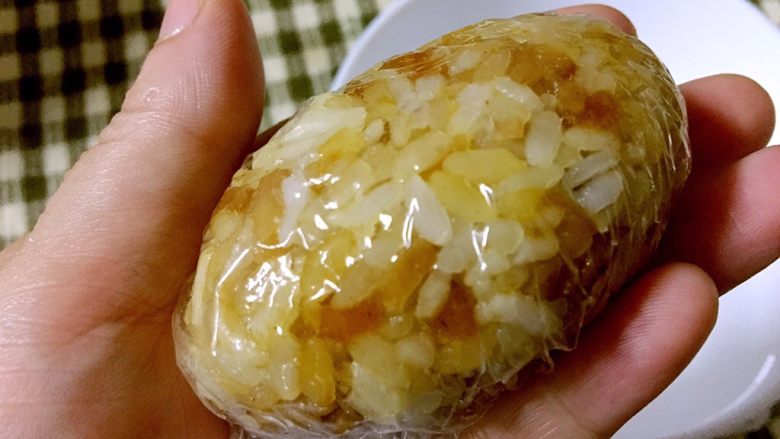 海苔肉松萝卜干饭团,用保鲜膜包起,捏成椭圆形