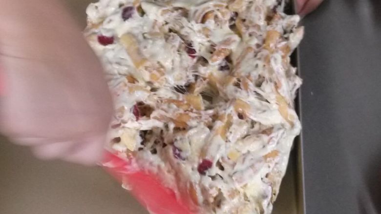 牛轧糖蔓越莓沙琪玛,找一个不粘的模具,将搅拌好的成品倒入模具中