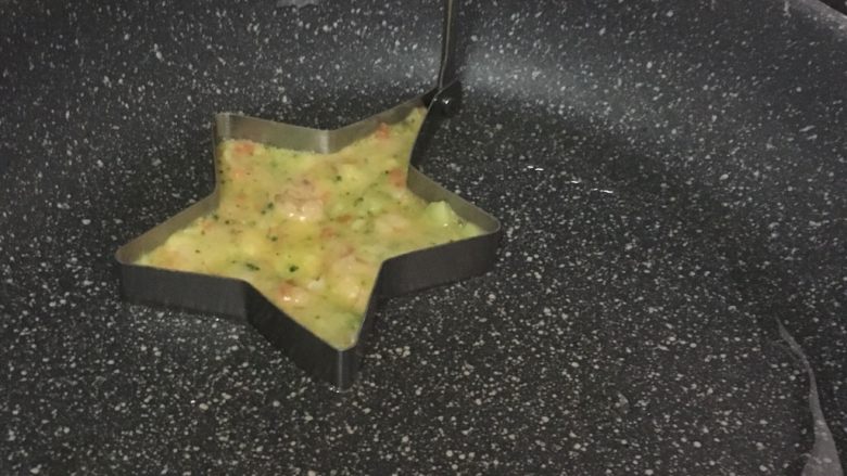 鲜虾蔬菜饼,热锅刷油,开小火,将面糊倒入煎蛋模具里,没有模具的直接舀一勺糊糊倒入锅中,然后用勺子摊成饼,尽量摊的薄点。待成行后取出模具,翻面煎另一面。