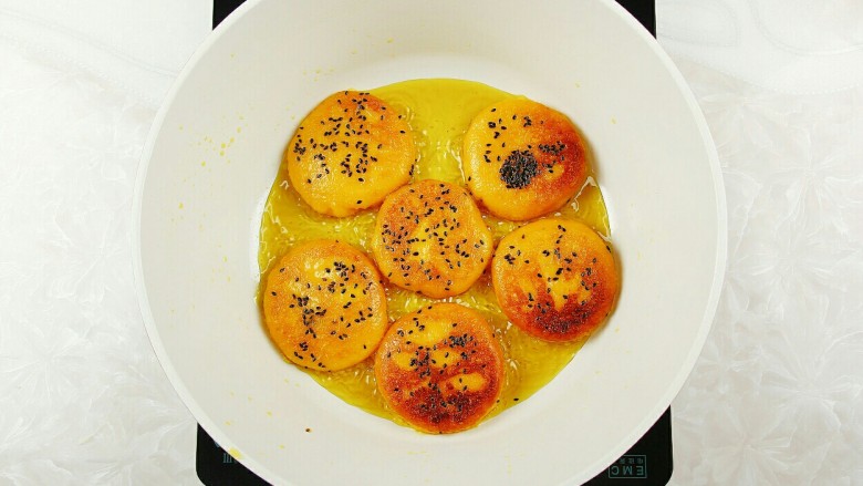 红薯糯米芝麻饼,炸三分钟左右翻面,炸至两面金黄