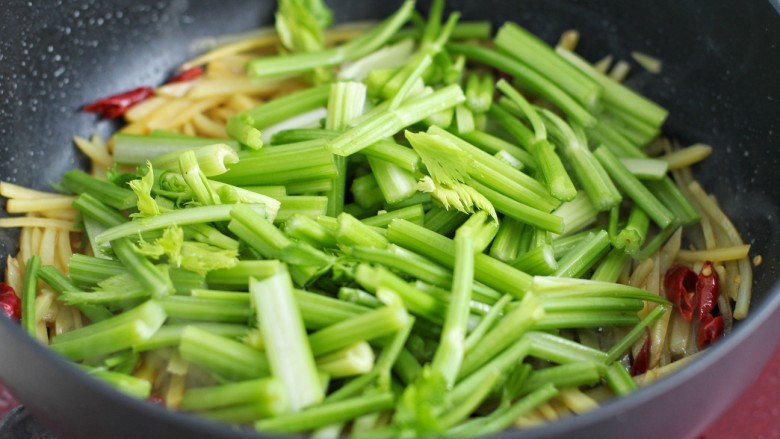 芹菜土豆炒肉丝,倒入芹菜炒匀