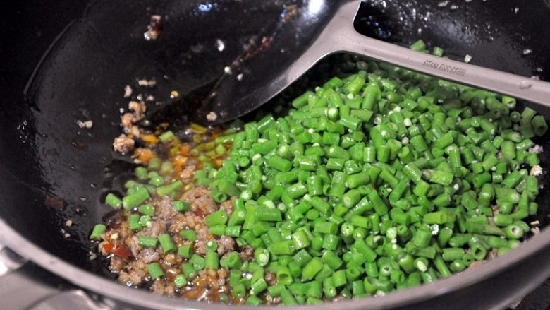 豇豆肉末,倒入焯过水的豇豆,翻炒均匀。