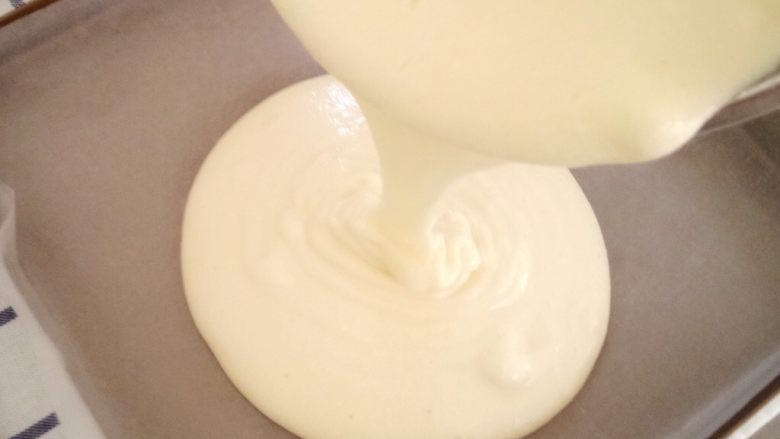 网红肉松小贝盒子,拌好的面糊倒入铺好油纸的烤盘中,因为面糊比较稀,所以轻轻晃一下烤盘就可以很均匀啦