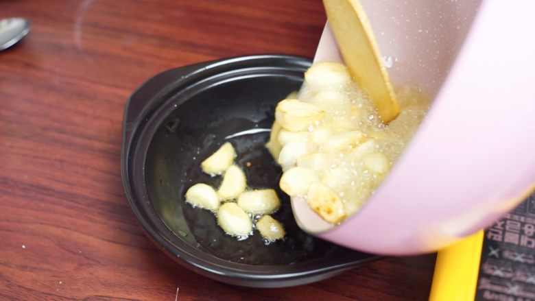 砂锅蒜香焖鮰鱼,炒至蒜子微黄,盛入砂锅