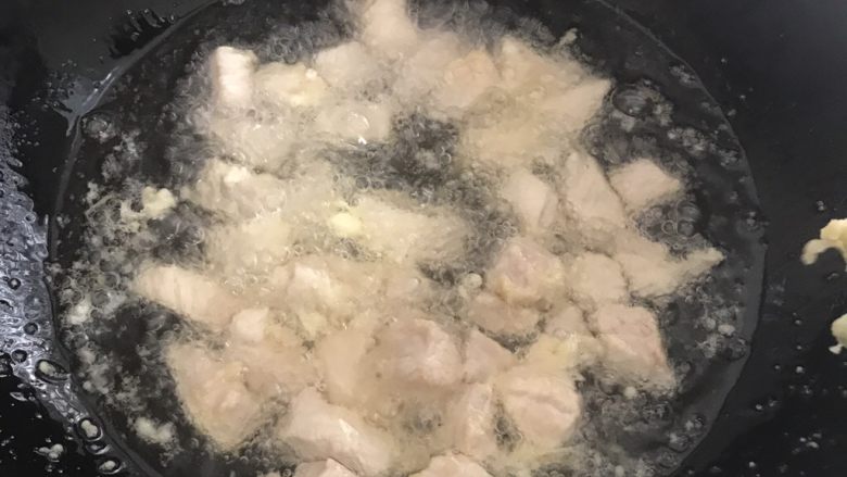 菠萝咕咾肉,下入肉块，拿筷子搅拌一下，使每块肉都能均匀受热
