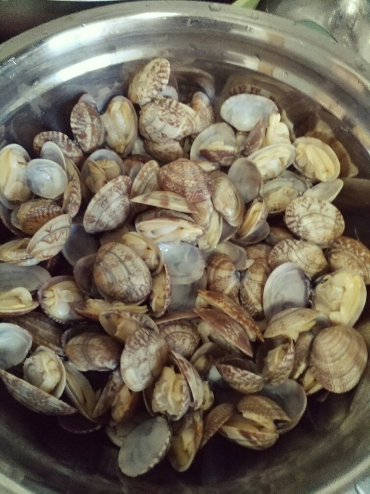 香辣爆炒花甲,漏勺捞出花甲,清水冲洗干净备用