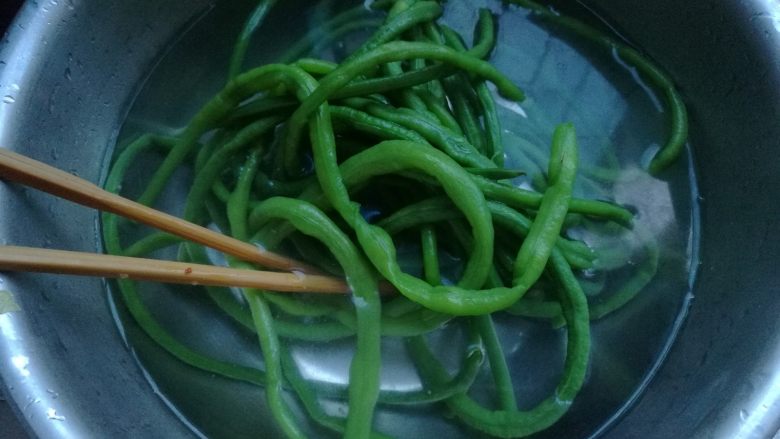麻酱拌豆角,准备一盆凉水,焯熟的豆角捞出放入盆内。(喜欢吃凉的还可以再继续过两遍、三遍凉水)