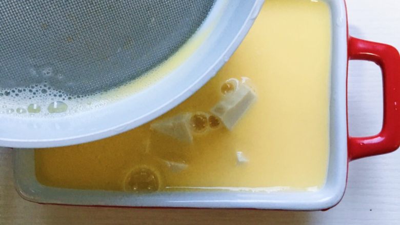 鲜虾豆腐蒸水蛋,鸡蛋液第三次过滤到装有豆腐的碗里 此时的鸡蛋液不再有泡沫啦 (大人食用的话需要在鸡蛋液里调味哦)