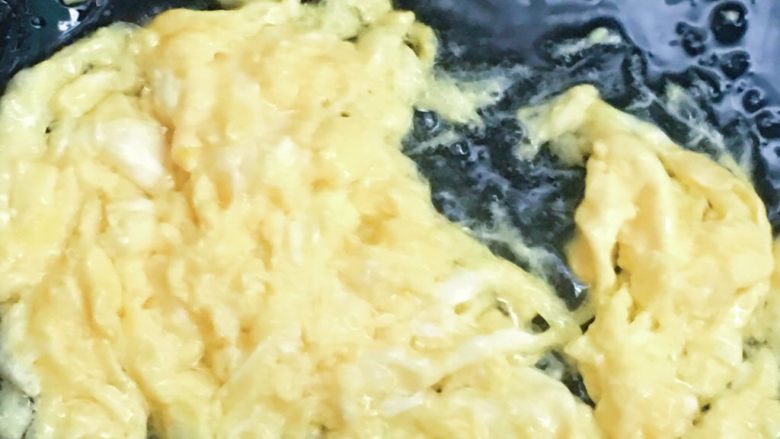 打卤黄花菜,用筷子搅拌锅中的鸡蛋,打碎,从锅中盛出来