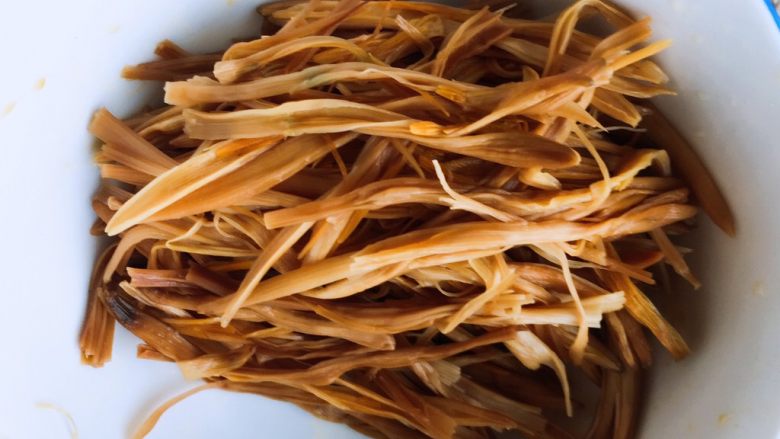 打卤黄花菜,将泡发的黄花菜的硬根部摘掉,再将黄花菜撕成丝