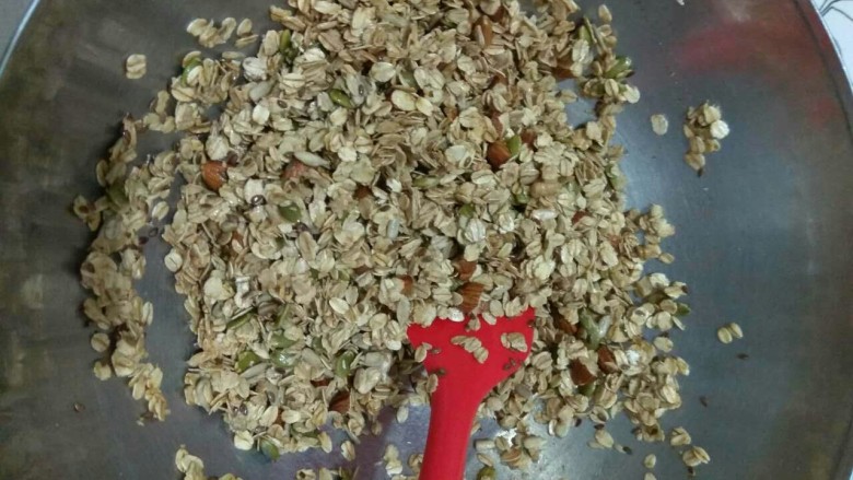 Granola格拉诺拉麦片,取出烤盘,将烤制中的麦片和坚果倒入大腕,迅速的和调味料搅拌均匀,并倒回烤盘,平铺均匀。
再烤制20~30分钟,中间看情况取出来搅拌一下再放回烤盘摊平,保证均匀的烤制。