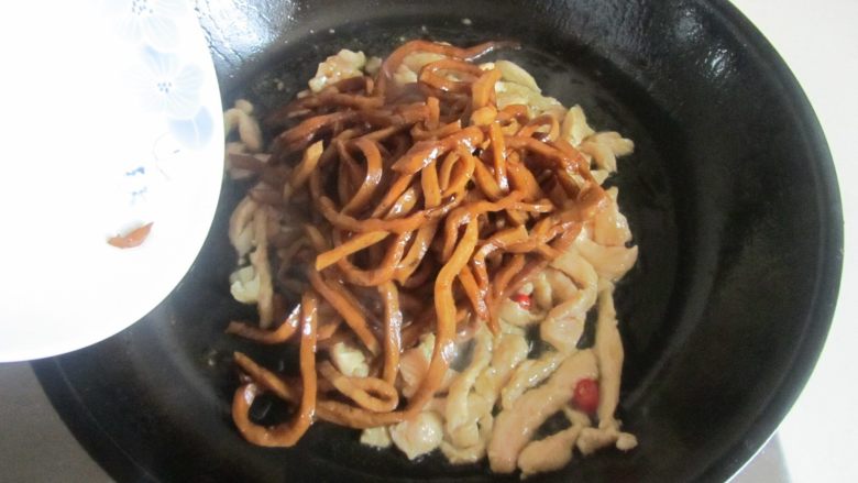 芹菜千叶豆腐炒鸡丝,翻炒至鸡丝变色后加入蒜末和红椒圈进去翻炒；