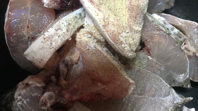 黄灯笼椒煮酸辣鱼,鱼块滤干水分后,撒上胡椒粉.