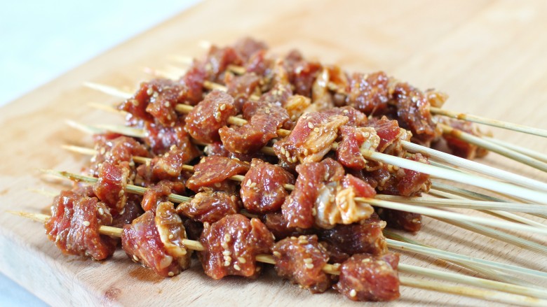 香烤肉串,把腌制好的牛肉块肥瘦相间的穿到竹签上,每块肉之间留一些空隙