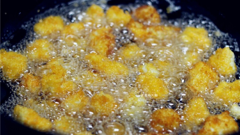 自制鸡米花,下入处理好的鸡肉丁,中小火炸至表面金黄
