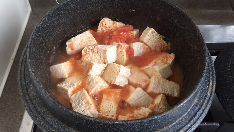 番茄炖冻豆腐,再加入冻豆腐,大火煮开,转小火炖煮5-10分钟。如果喜欢汤汁浓稠,可以大火稍微收汁2分钟,这是个汤菜,不能收干汁水。