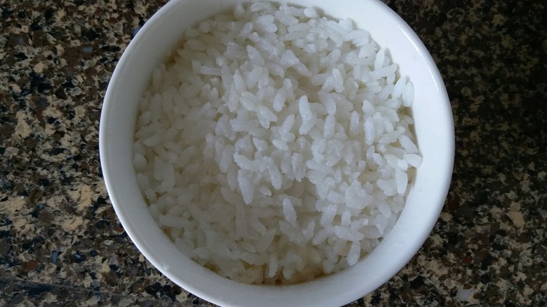 牛肉咖喱饭,把煮好的白米饭盛到碗里,用勺子压紧实