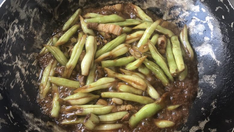 豆角焖面,随后加入半碗白开水，焖15-20分钟左右，因为豆角不容易熟，所以时间要稍久一些。随后加入熟炒面，并盖上锅盖焖3分钟。然后加入盐两勺，<a style='color:red;display:inline-block;' href='/shicai/ 5506'>麻油</a>4勺。翻炒出锅。