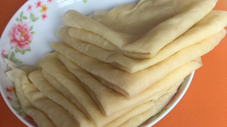 春饼,将重叠的饼分开 折成三角