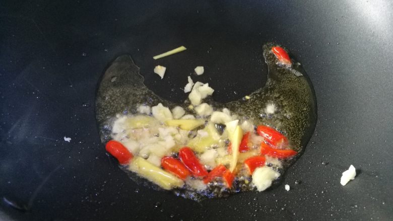 酸豆角炒牛肉末,热油锅，放入姜、蒜、酸辣椒爆香。