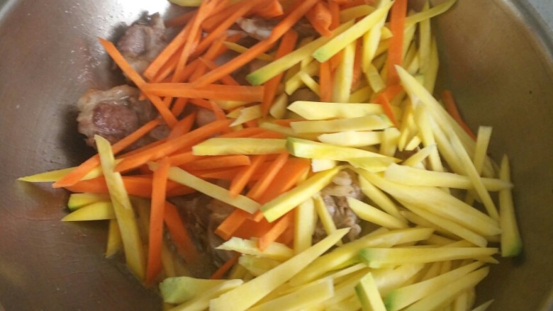 新疆羊排抓饭,倒入黄萝卜和胡萝卜翻炒,放入盐。