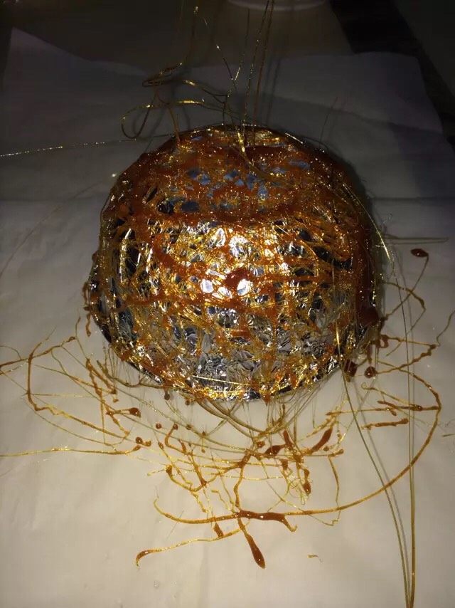黄金盘丝洞,这一步要快速完成,用勺子勺一点点甩在碗上(糖酱很烫,动作要快也要小心操作)。