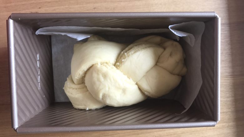 椰蓉面包(70%中种完美拉丝),整形:用一把锋利的刀把卷好椰蓉馅的面团对半切开。顶部不切断。然后像拧麻花一样,柠成一双股辫,再对折。(也可以编三股辫,造型随意)