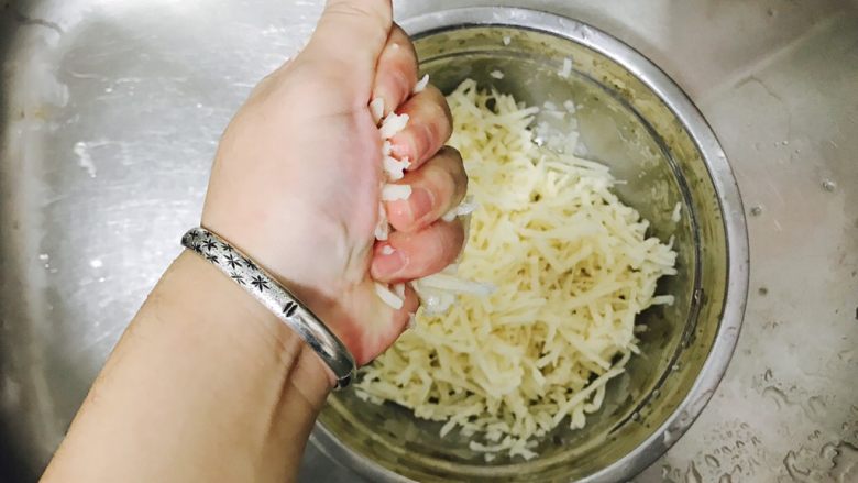 香煎藕饼,用手抓一小球的分量,用力将莲藕丝儿的水分给挤掉,放在一旁待用