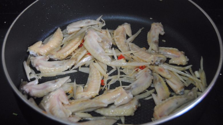 孜然子姜鸡翅尖,倒入<a style='color:red;display:inline-block;' href='/shicai/ 718'>料酒</a>,盐翻炒