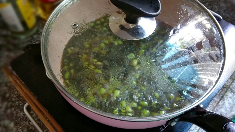 紫苏毛豆,盖上锅盖,转中小火焖煮15到20分钟,至豆子酥软。