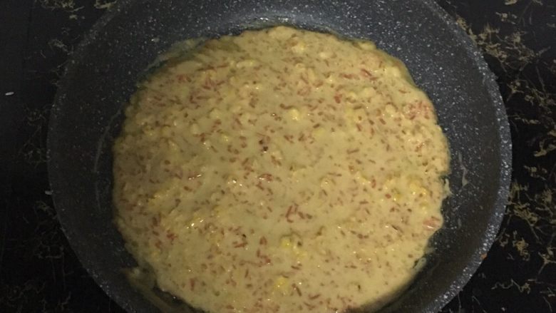 玉米胡萝卜蛋饼,热锅刷油,开小火,倒入面糊,迅速的晃动平底锅,使面糊均匀的平铺在锅里。待饼凝固后,翻面继续小火煎至金黄色。