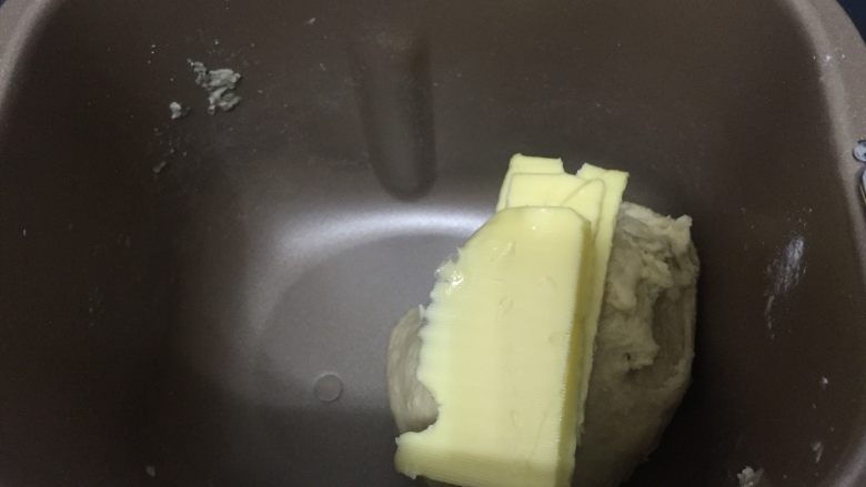卡路里炸弹 咕咕霍夫重油面包,25分钟后,将软化的黄油分3次加入到面团中,因为这个面包的黄油含量高,不是很容易吸收,所以一定要分次加入,融合后再加下一次黄油
