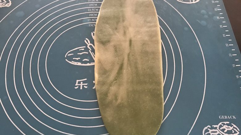 抹茶紫薯蛋黄酥,取第一个包好的面团,收口朝上擀成长舌形,