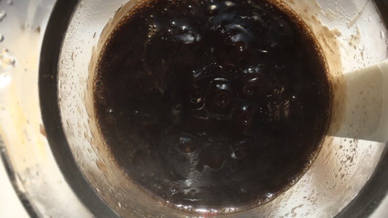 夏日甜品烧仙草,一边加热一边搅拌,大概2分钟,变成黑色粘稠状关火(如果你们用显示温度的锅加热,大概75度就可以了)。