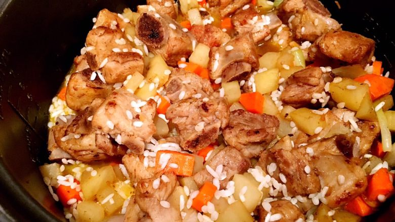 土豆排骨焖饭,大米洗好放电饭锅里备用,将炒好的土豆排骨倒入电饭锅里,搅匀,加平时煮饭四分之一的水。接着开始焖饭,等着电饭煲煮就好了。