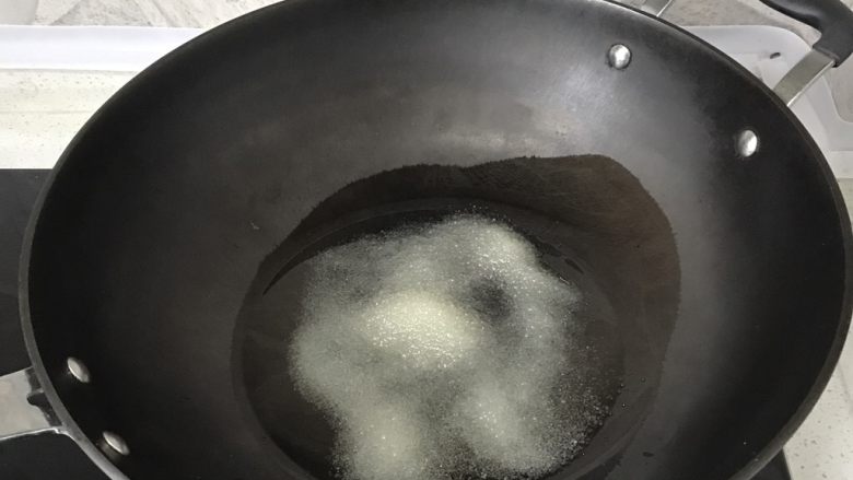 大盘鸡,热锅凉油,油稍多,倒入食用油后加入4勺白砂糖,中火,用锅铲慢慢搅动,待砂糖融化,颜色变深,大面积冒泡后,准备放入鸡块。